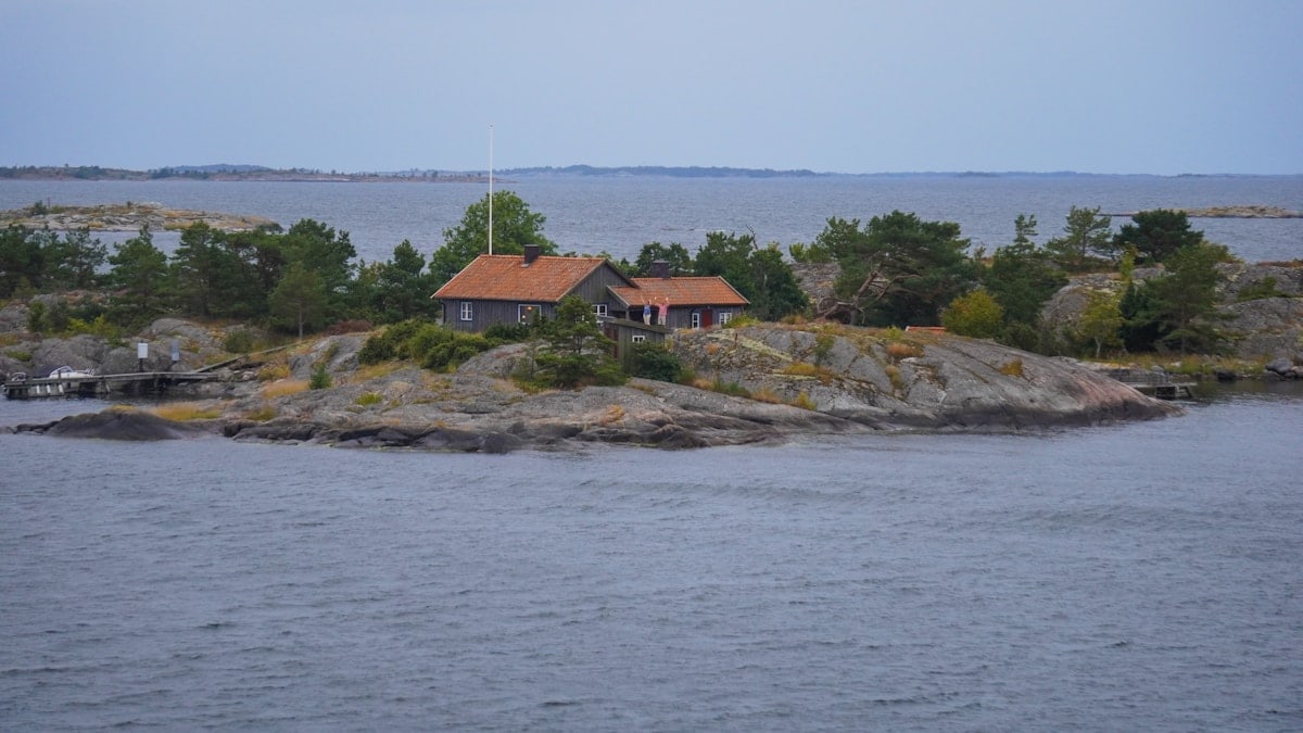brown and gray house near ocean under blue sky